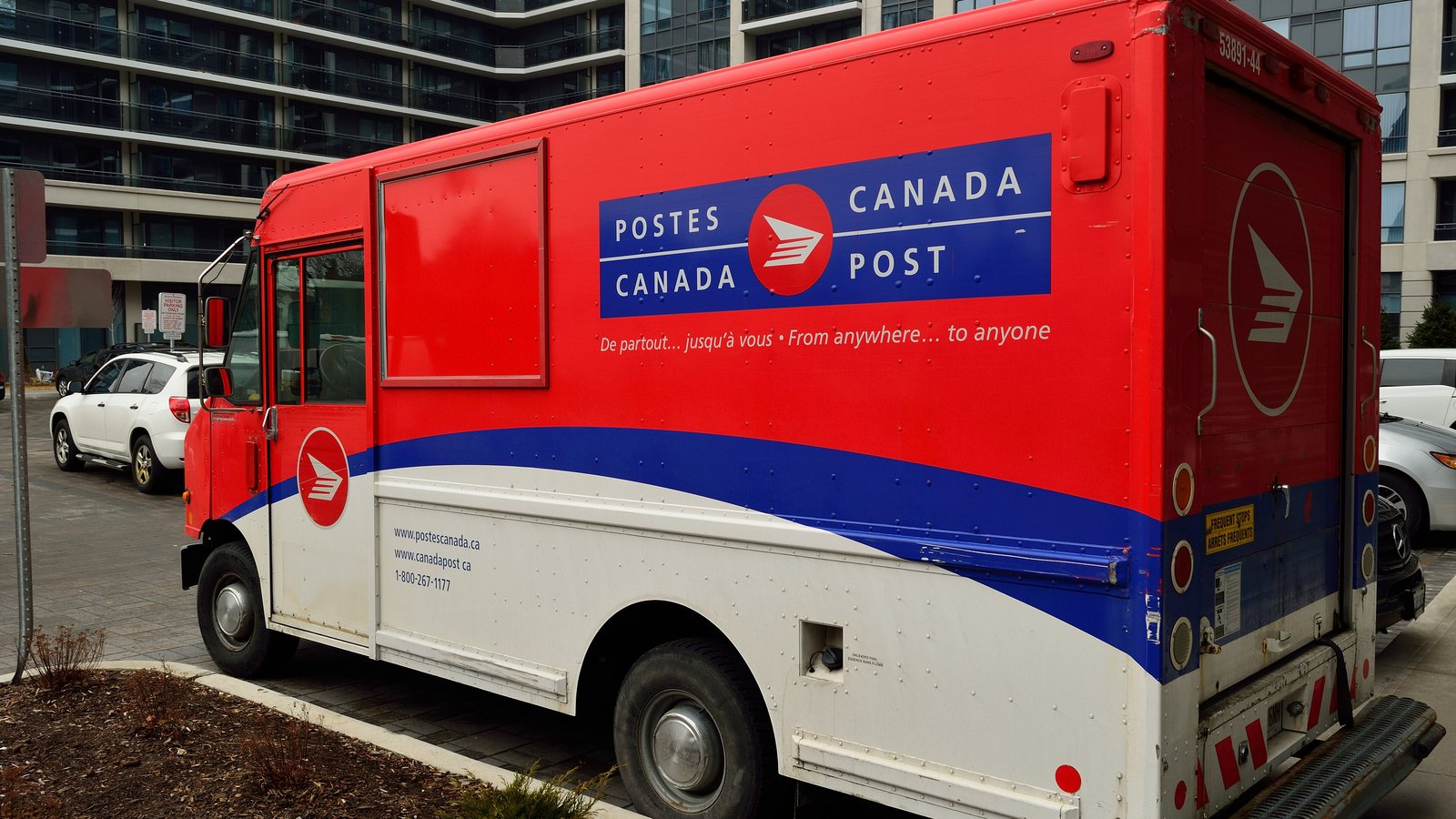 A red Canada Post delivery truck parked on a street