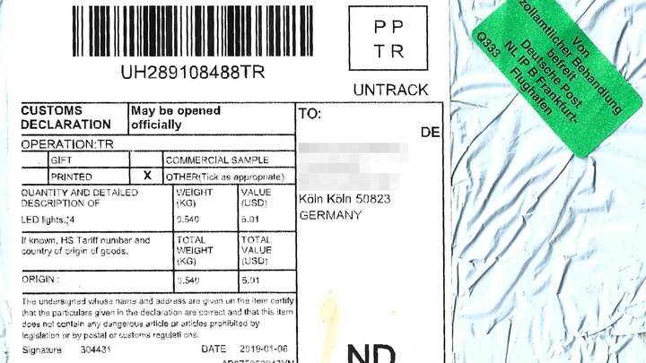 A postal customs declaration label on a small packet from China, listing LED lights with a declared value of 6.01 US dollars, with the recipient's name blurred and a green customs sticker in the corner