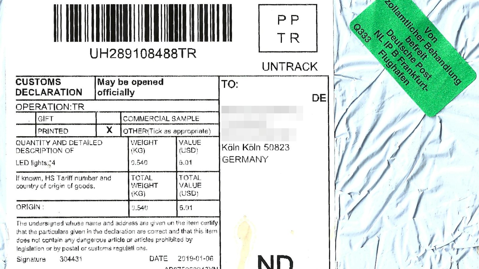A postal customs declaration label on a small packet from China, listing LED lights with a declared value of 6.01 US dollars, with the recipient's name blurred and a green customs sticker in the corner