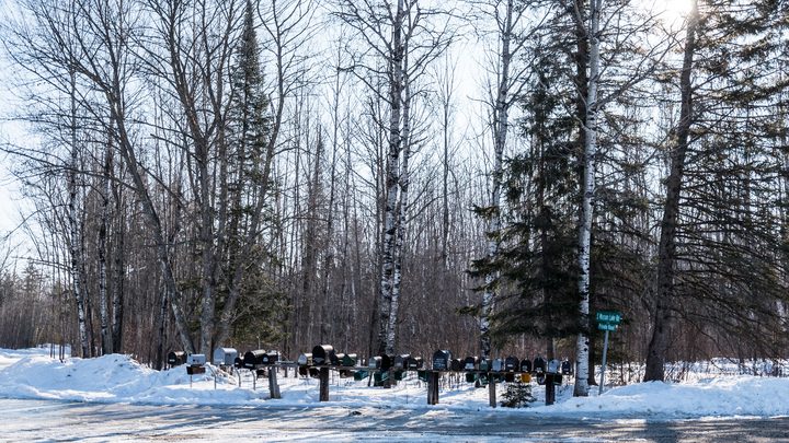 Une rangée de boîtes aux lettres rurales au bord d'une route enneigée dans le nord du Minnesota