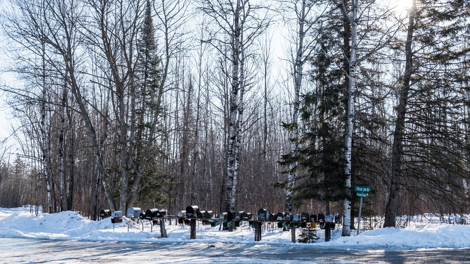 A row of rural mailboxes beside a snowy road in northern Minnesota