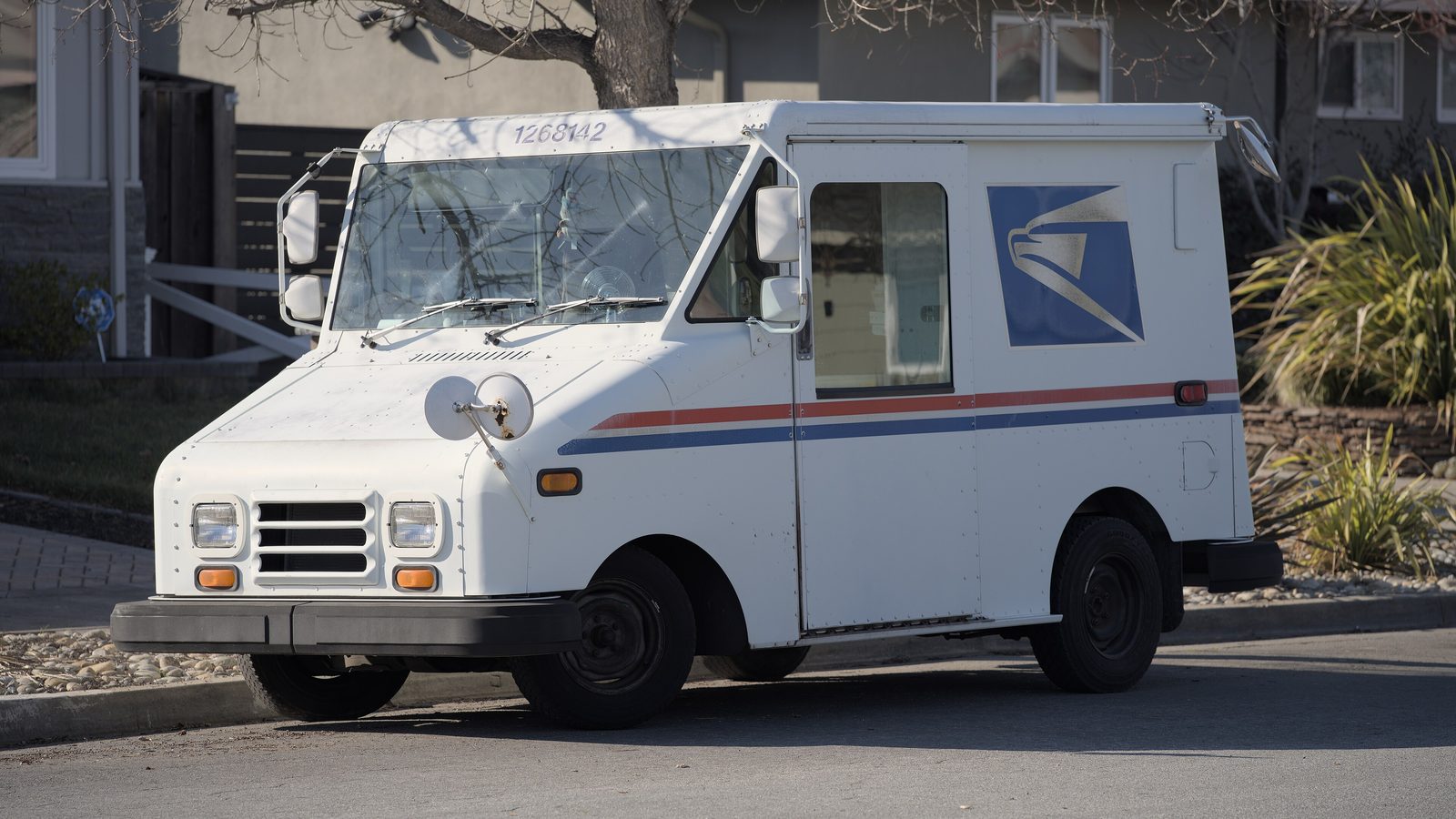 Camion postal USPS blanc garé dans une rue résidentielle